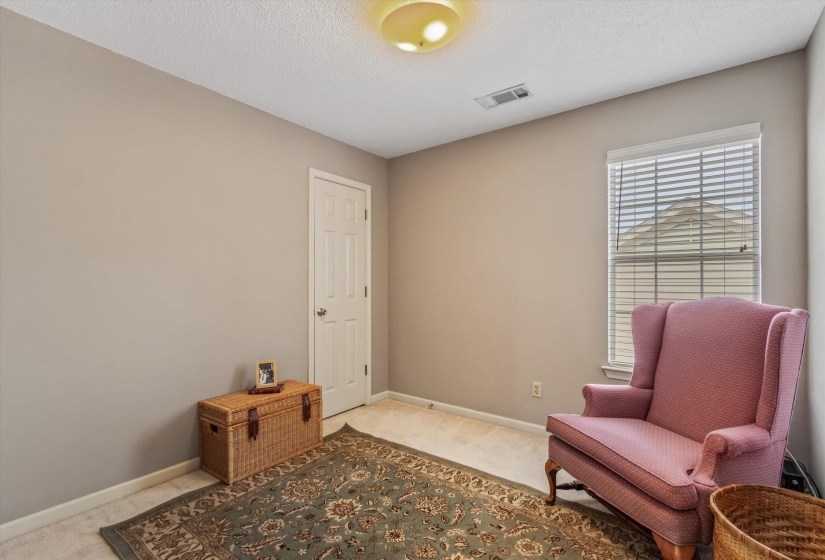 Carpeted room featuring neutral wall paint, a white paneled door, and a single window with white blinds