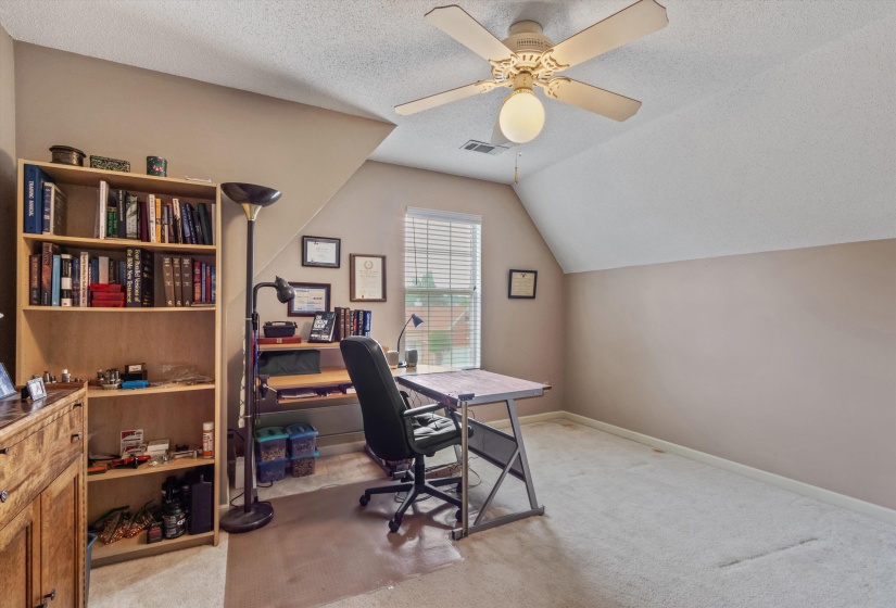 Carpeted room with a ceiling fan, sloped ceiling, and a window featuring horizontal blinds