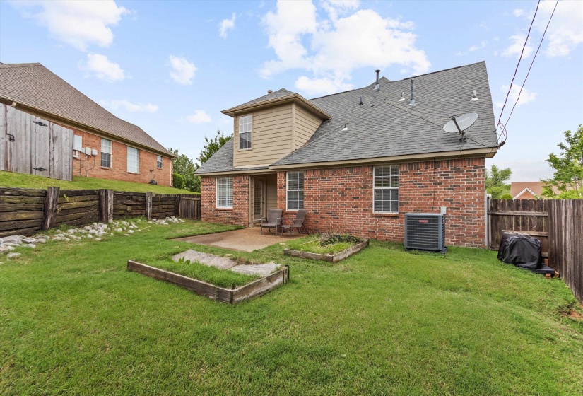 Brick and siding exterior featuring a gray shingle roof, double-paned windows, and a rear patio