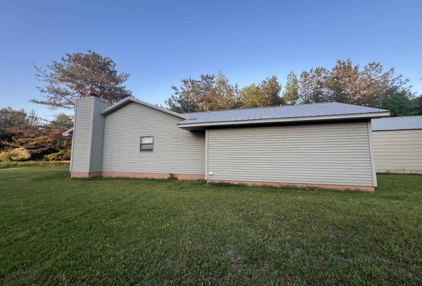 Light gray horizontal siding with a matching chimney and a metal roof