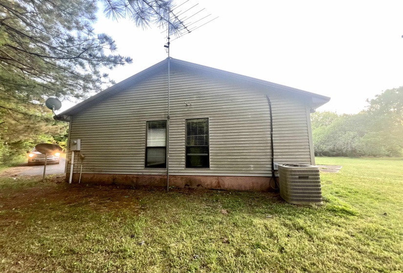 Side exterior featuring horizontal siding and two windows with blinds