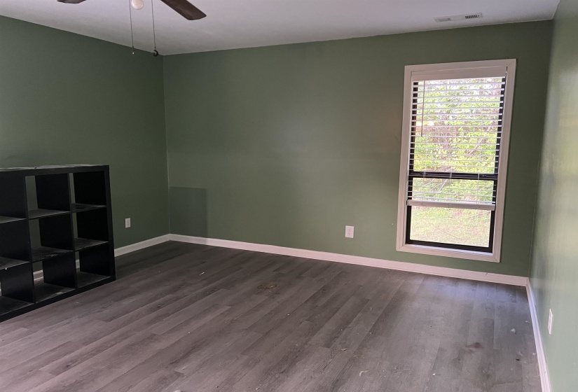 Room featuring vinyl plank flooring, a ceiling fan, a window with blinds, and painted walls ceiling fan with light
