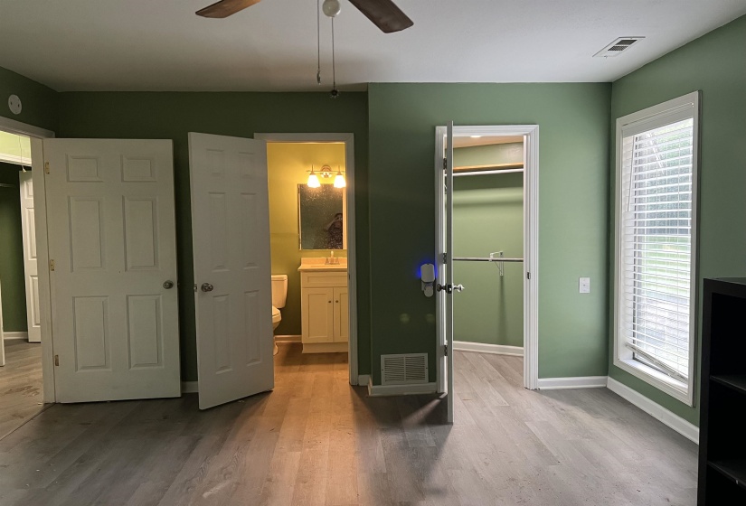 Interior space featuring vinyl flooring and sage green walls, private bath  ceiling fan