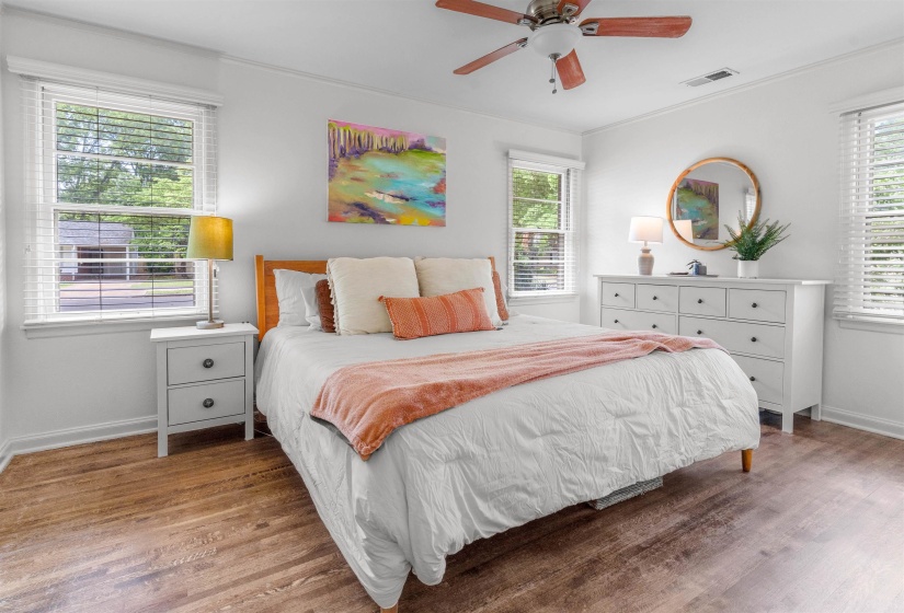 Bright room featuring wood-finish flooring and a ceiling fan