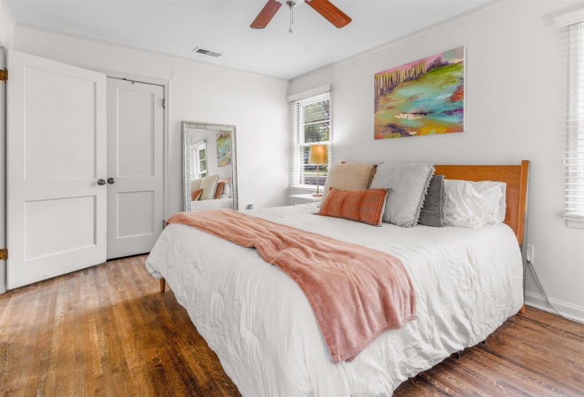 Bedroom featuring wood-finish flooring, white walls, and a ceiling fan