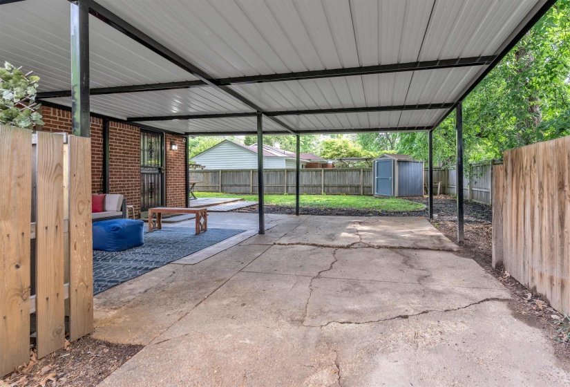 Covered patio area featuring a concrete surface and direct access to the brick-clad exterior