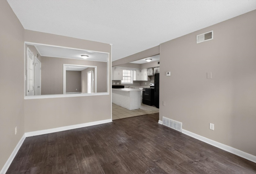 Open-concept living area featuring wood-finish flooring, neutral wall paint, and white trim