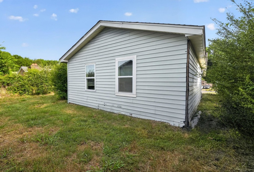 Light blue siding exterior featuring a white trim roofline and white-framed windows