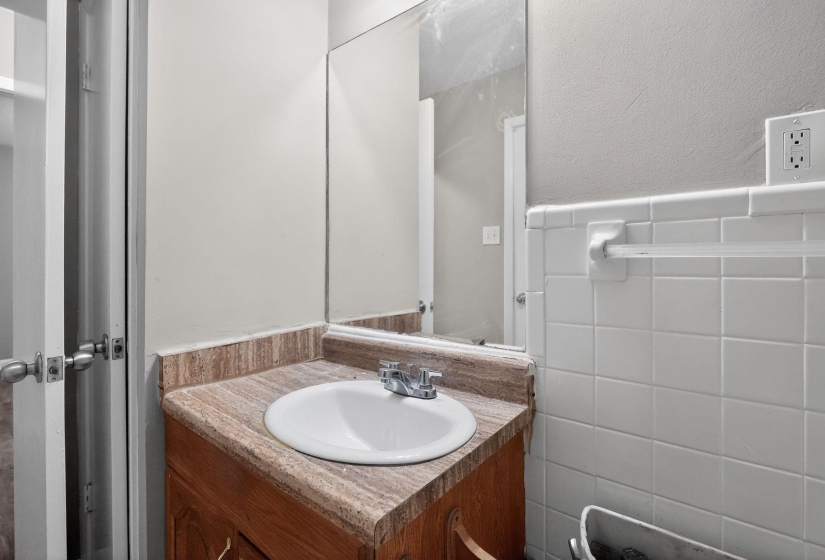 Vanity with an integrated white sink and chrome faucet, set atop a wood-finish cabinet