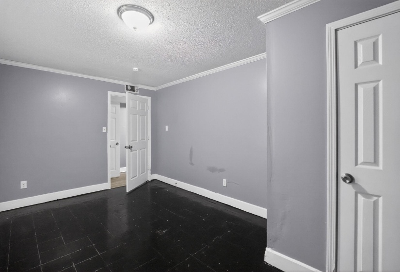 Room featuring dark wood-finish flooring, light gray walls, and white crown molding