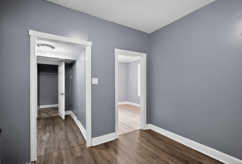 Interior room with gray walls, white trim, and wood-finish flooring