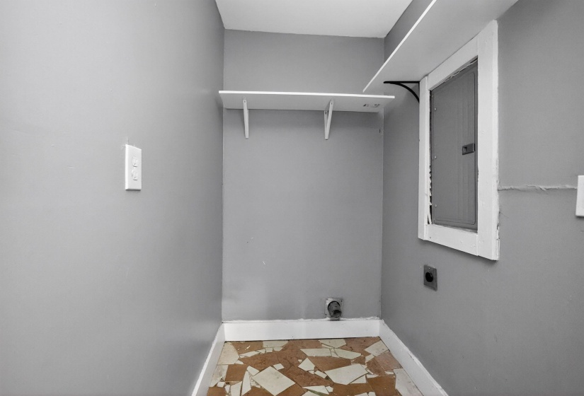Utility space with light gray painted walls and white baseboards