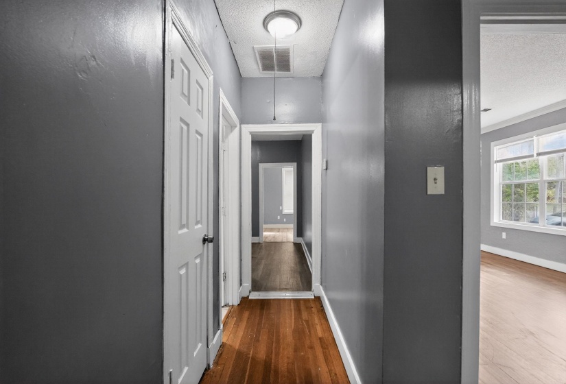 Hallway featuring wood-finish flooring and neutral-toned walls