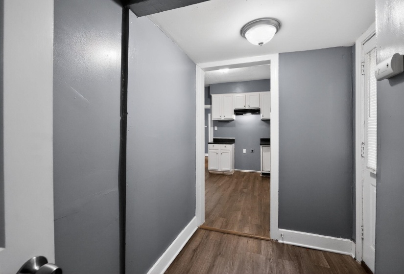 Kitchen featuring white cabinetry, dark countertops, and wood-finish flooring
