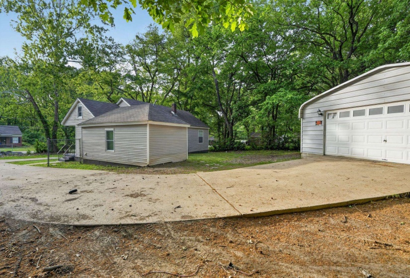 Detached garage with horizontal siding, a multi-pane overhead door, and exterior lighting