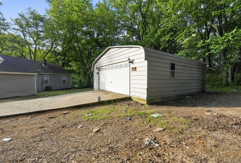 Detached garage with metal siding, a single overhead door, and a side window