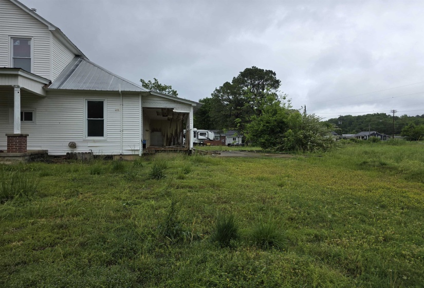 Expansive open lot with mature greenery and partial house structure