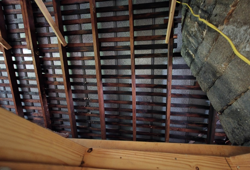 Exposed roof rafters with wood lath detailing, concrete block wall construction, and unfinished wood framing