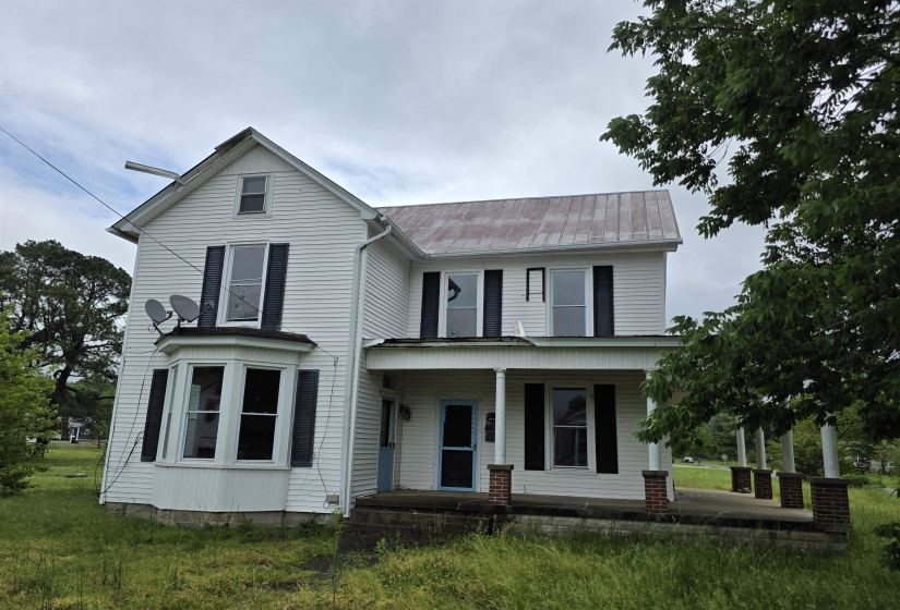 Two-story residence with white siding and a covered front porch featuring brick-column bases