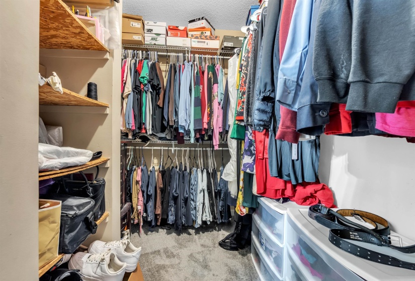 Walk-in closet featuring built-in wire shelving, adjustable hanging rods, and corner shelving for storage