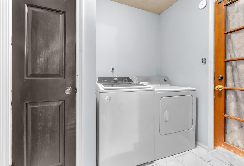 Laundry area featuring light blue walls and white tile flooring