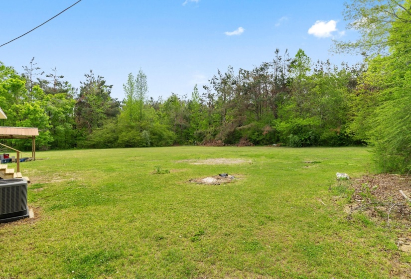 Expansive green lawn providing ample open space, bordered by mature trees