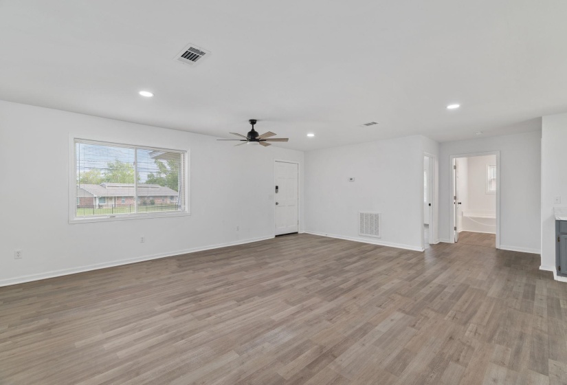 Spacious living area featuring wood-finish flooring, recessed lighting, and a modern ceiling fan