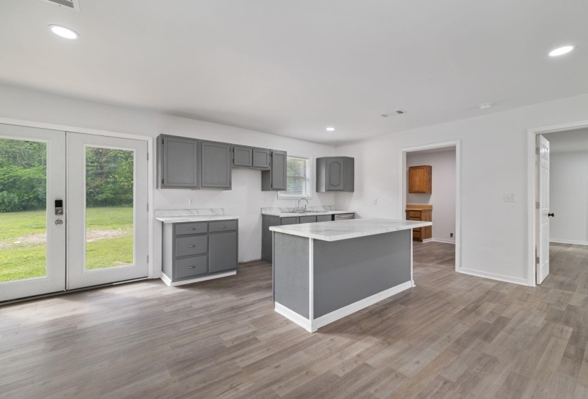 Kitchen featuring a central island with countertop, gray cabinetry, and light wood-finish flooring