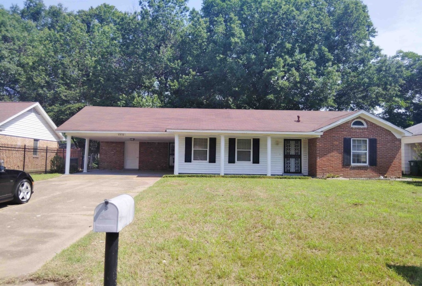 Single-story home featuring a brick and siding exterior, front lawn, and paved driveway