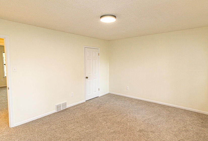 Neutral-toned walls complement the textured carpet flooring