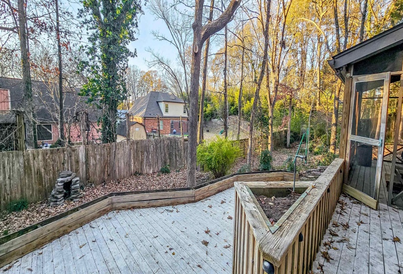 Expansive wood deck with built-in planters and perimeter fencing