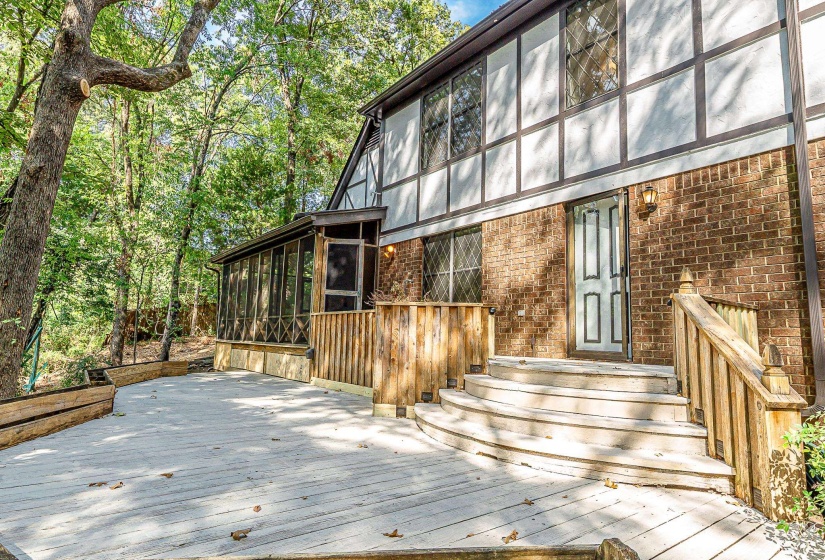 Multi-level wood deck featuring curved stairs and a wood railing