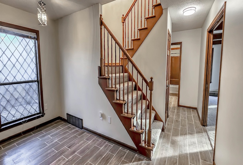 Interior staircase featuring wood banisters and carpeted treads