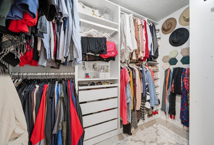 Custom closet system featuring multiple hanging rods, integrated shelving, and white drawer storage