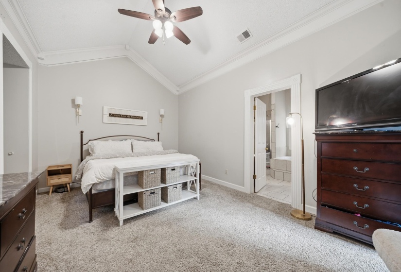 Spacious room featuring vaulted ceilings with crown molding, a ceiling fan, and wall sconces