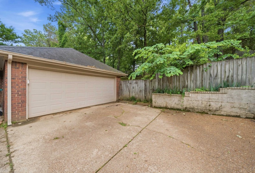 Attached two-car garage with brick veneer siding and a concrete driveway