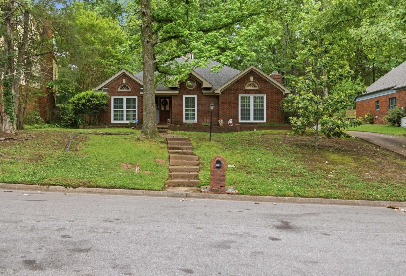 Traditional brick residence featuring a prominent front entrance with a dark wood door