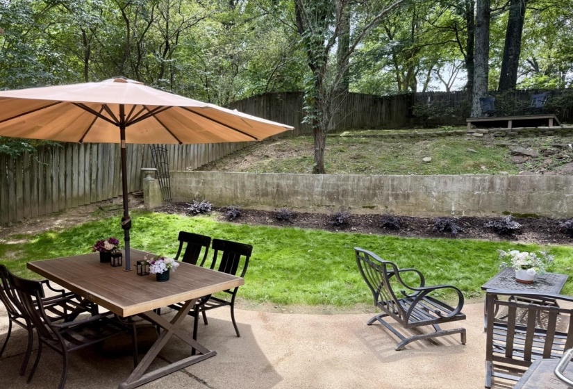 Expansive concrete patio area with a manicured lawn