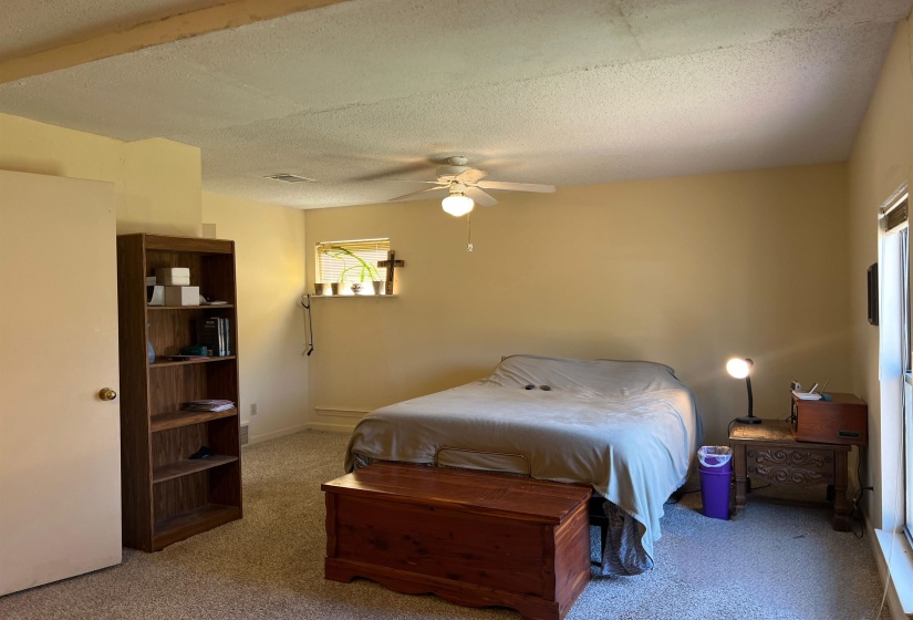 Carpeted bedroom featuring baseboards, a textured ceiling, and ceiling fan