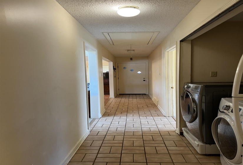 Laundry area featuring washer and dryer, a textured ceiling, baseboards, attic access, and laundry area