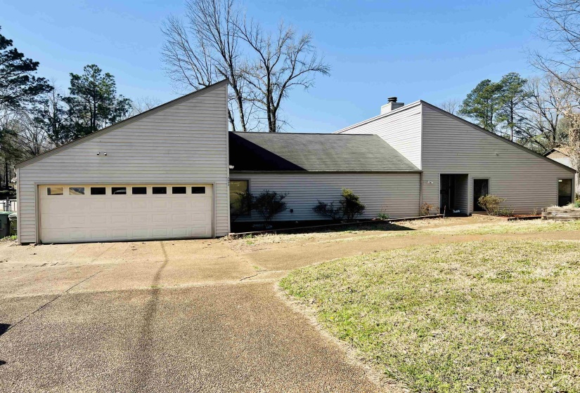 View of property exterior featuring an attached garage, a yard, circular drive with Open Floor Plan and Lakefront Living.