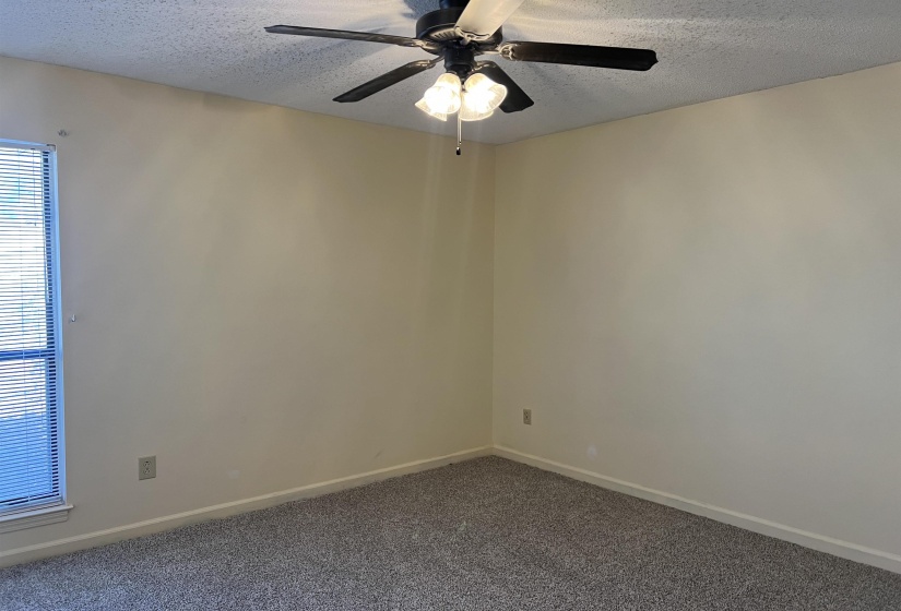 Room featuring baseboards, a textured ceiling, ceiling fan, and light carpet