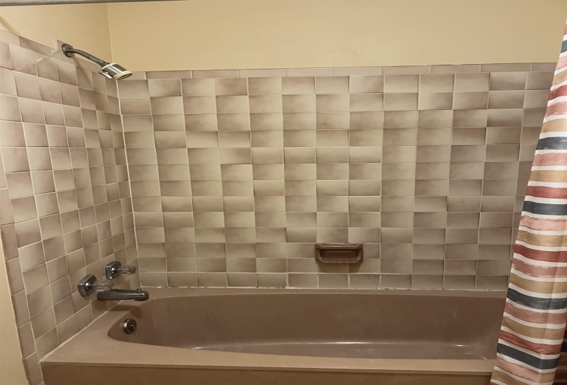 Bathroom featuring shower / bathtub combination with curtain