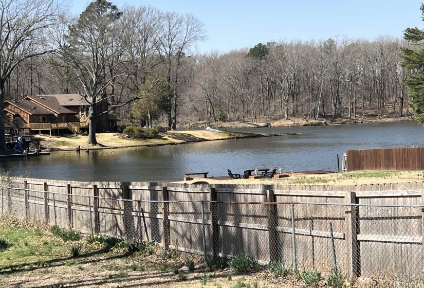 Water view with a forest view and fence