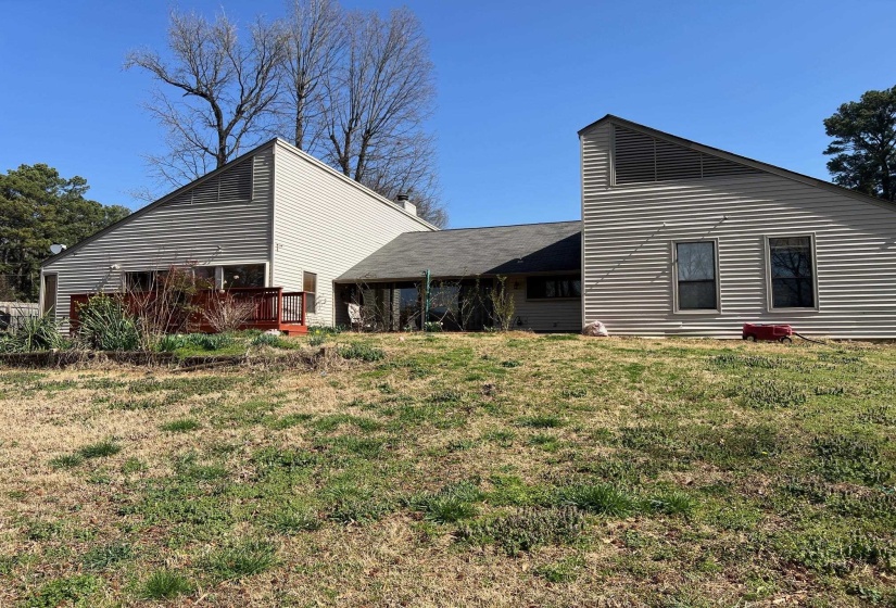Rear view of property featuring a lawn and a deck