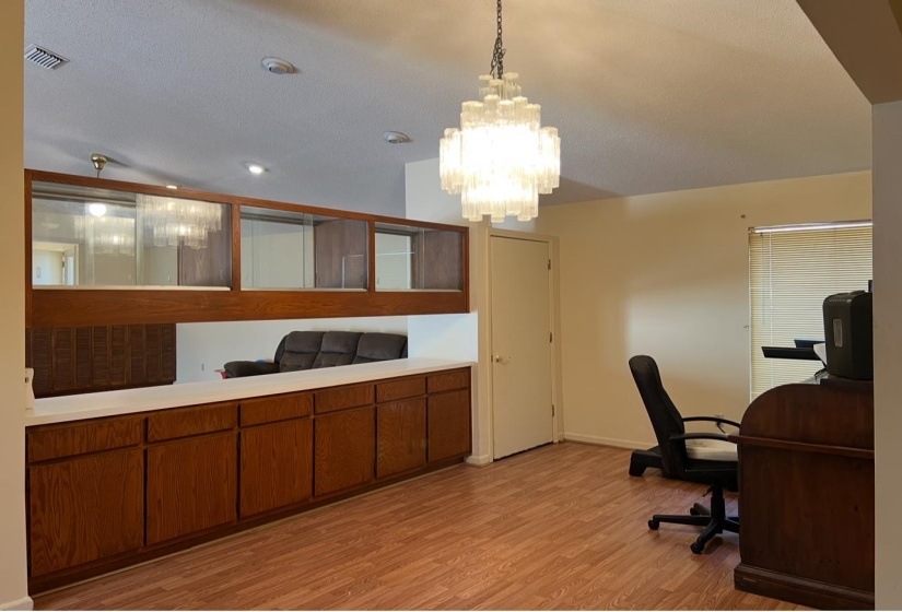 Dinig area featuring light wood-type flooring, baseboards, visible vents, and a chandelier