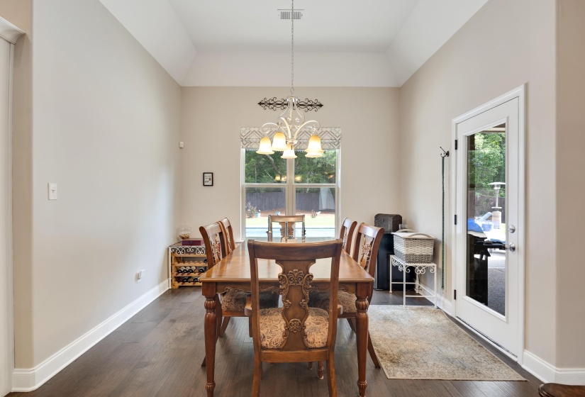 Spacious room featuring wood-finish flooring, a tray ceiling, and neutral wall tones
