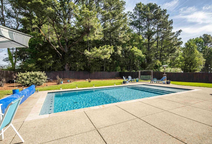 Rectangular in-ground pool surrounded by a large concrete patio
