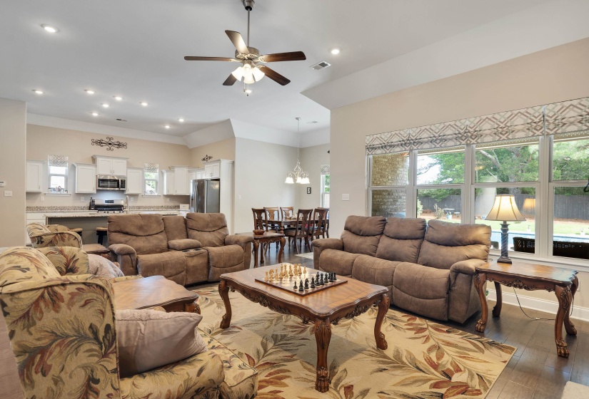 Open-concept living space featuring wood-finish flooring, recessed lighting, and a ceiling fan