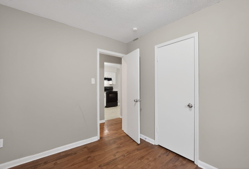 Interior space featuring wood-finish flooring, light gray walls, and white trim